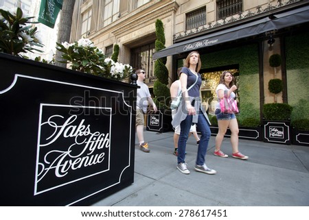 NEW YORK CITY - FRIDAY, MAY 8, 2015: Pedestrians walk past Saks Fifth Avenue in Manhattan. Saks Fifth Avenue is an American department store chain owned by the Hudson\'s Bay Company.