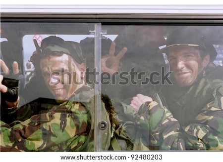 DURRES, ALBANIA - APRIL 22: Fresh Kosovo Liberation Army recruits from southeastern England give the V for victory sign through the window of their minibus, taking them to the Yugoslavian border on April 22, 1999 in Durres, Albania