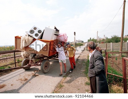 KOSOVO POLJE, KOSOVO, 29 JUNE 1999 --- A Kosovar Gypsy family flees their home after ethnic Albanians sought revenge on Gypsies who collaborated with Serbs during the war of independence.