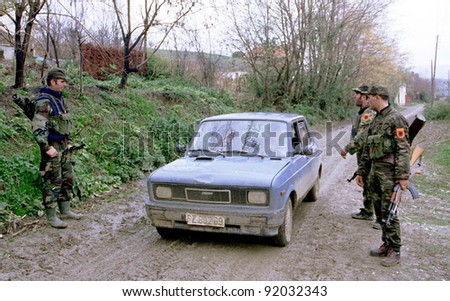 RETMILJE, KOSOVO,  12 NOVEMBER 1998 --- Soldiers of the Kosovo Liberation Army (KLA) stop a car at a makeshift roadblock in the Drenica Triangle.