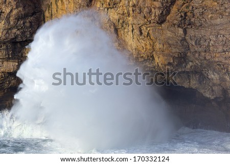 Big waves hammer against the cliffs on Algarve