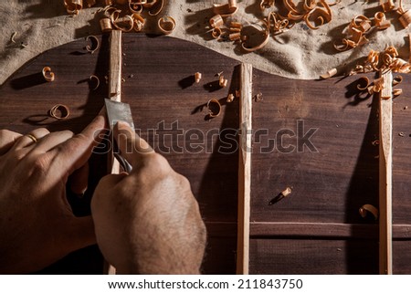 Luthier building guitar at table in workshop