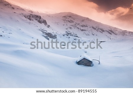 little stone cabin in winter sunset, plenty of snow