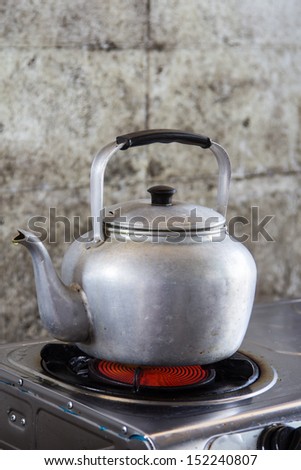 Aluminum tea kettle is on the stove.