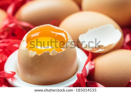 fresh brown eggs and one eggs is broken on tray