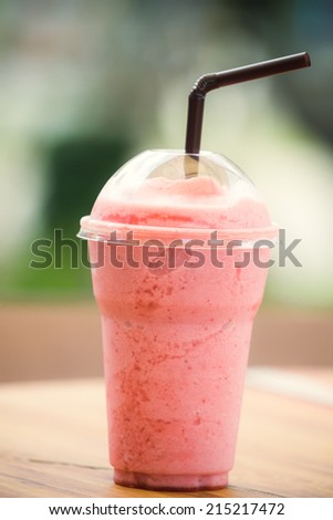 strawberry smoothie on wooden table in bakery shop