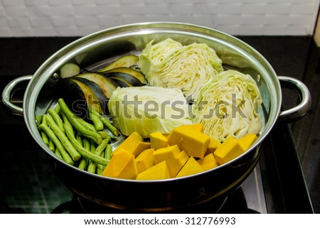 Pumpkin, cabbage, beans, eggplant in steaming pot