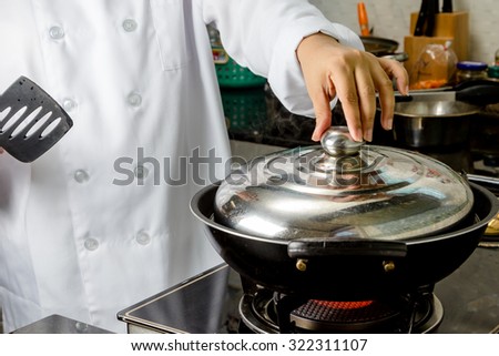 chefs opening the pan lid on hot stove