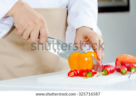 chef slicing chili peper for cooking