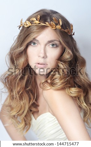 the beautiful gentle young bride with ornament on hair on a white background