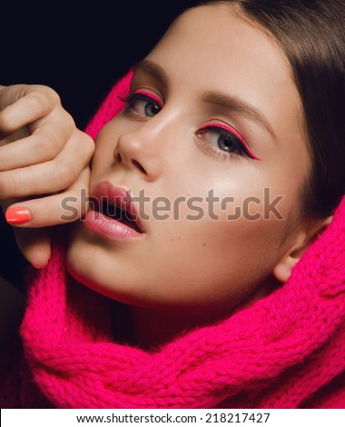 portrait of a beautiful young girl with dark hair, pink accessory, with a beautiful velvet glowing skin and bright pink plump lips on dark background
