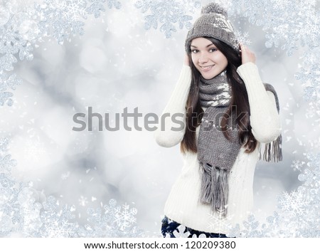 Beautiful young brunette with winter clothes on silver background