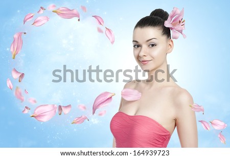 Beautiful brunette woman with flower petals - body and skin care concept