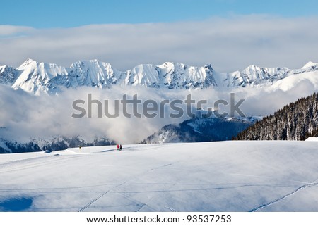 Panoramic View on Mountains and Two People Trekking in French Alps
