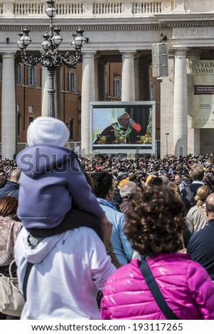 ROME - APRIL 13 2014: A group of believers, in St. Peter\'s Square on Palm Sunday during the Eucharistic blessing of Pope Francis. Pope Francis on the big screen. April 13, 2014, Vatican City, Italy