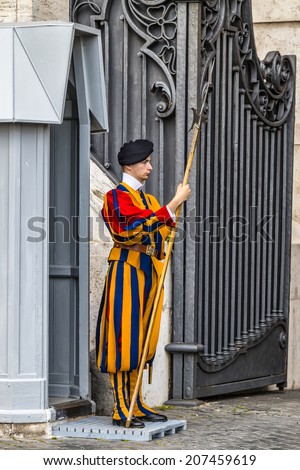 Rome, Italy - July 12, 2014: Swiss Guard at the entrance of the Vatican City in defense of the pope. Vatican City, Rome, Italy