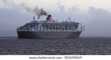 OBAN, ARGYLL AND BUTE, SCOTLAND - MAY 22: RMS Queen Mary 2, leaving Maiden Island on May 22, 2015 in Oban, Argyll and Bute, Scotland.