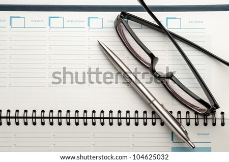 Open weekly planner showing hourly schedule with pen isolated on white.