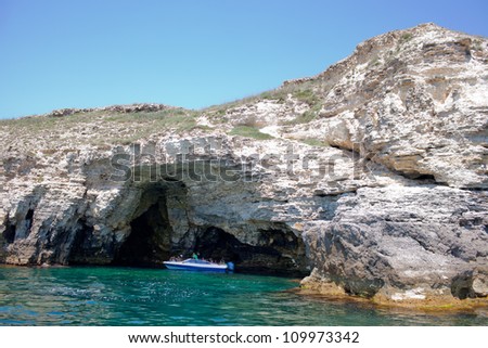Tourists on boat go inside grotto