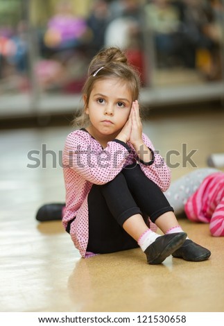 5 year old little girl doing dance exercises on the floor