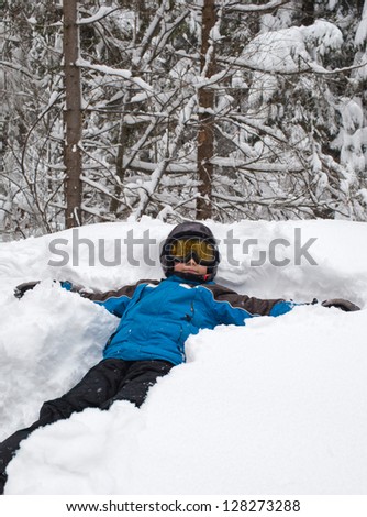 Portrait of lIttle skier lying on a snow face up