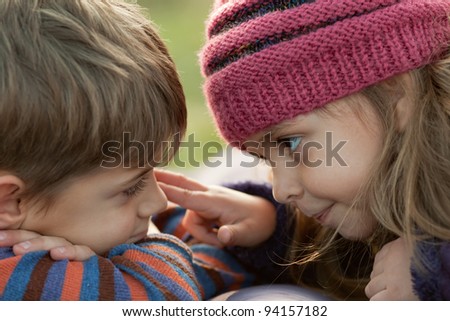 Little girl is pointing to her brother\'s eye and boy let her investigate