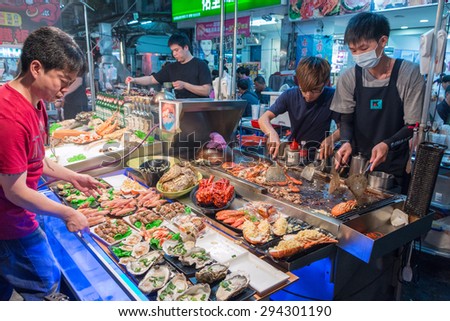 KAOHSIUNG, TAIWAN - APR 20 : Chief prepares seafood to be sold in Kaohsiung night market on April 20, 2015. People enjoy food at night market in Taiwan. And is one of the unique culture in Taiwan.
