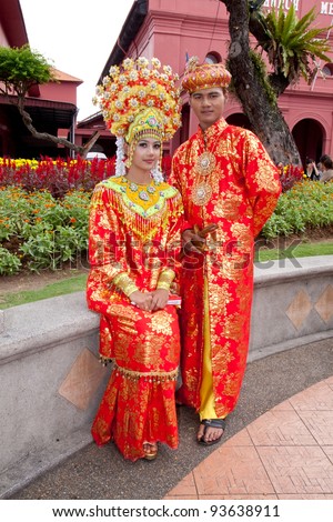 MALACCA,MALAYSIA-JAN 1: Malay couple in their traditional Malacca Malay costume on JAN 1,2012 in Malacca.The Malacca Malay matrimonial gown and accessory are the mixture of Malay and Chinese influence