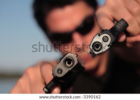 A man holding a pistol and pointing it at the camera. (This image is part of a series).