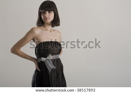 An 18 year old exotic brazilian model, with short dark hair, a young looking face and a skinny body. This was shot in a studio and she\'s weariing a black, strapless dress. Plenty of copyspace.