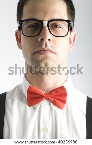 A young, caucasian nerd, close-up, on a light gray background.