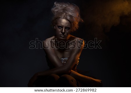 Gilt. Golden Plated Woman's Face. Art concept. Gilded Body. Focus on her hands