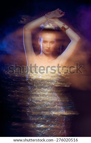 Young, beautiful and rich woman in jewels of gold and stones over luxury background