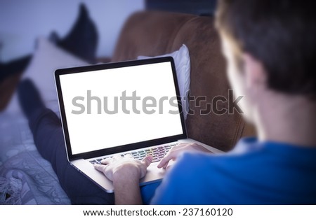 Man using laptop while sitting on sofa.