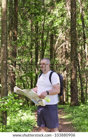 A man with a map on the trails in the forest