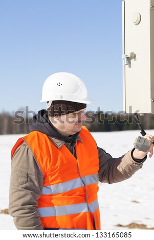 Electrical engineer with electrical cable near switchboard