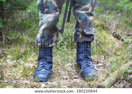 Soldier\'s legs in army boots in a forest