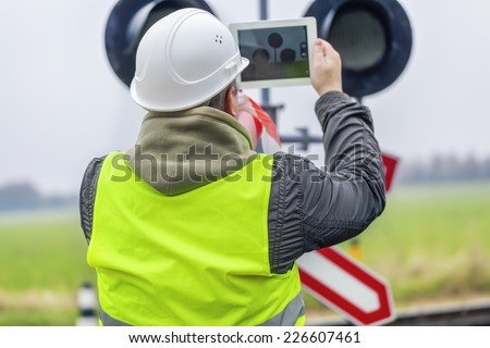 Railway engineer with tablet PC near the railway