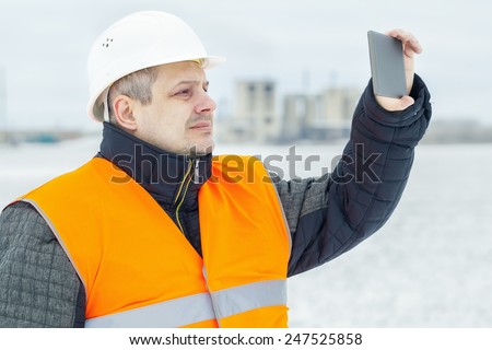 Engineer with tablet PC on the field in winter