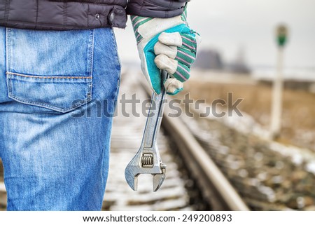 Man with adjustable wrench on the railroad