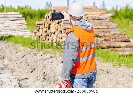 Forest engineer with tablet PC in forest