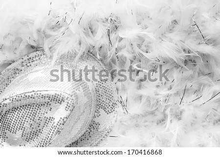 Black and white style party background with white sequins hat and feather boa