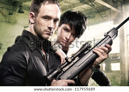 Lovely couple with gun in factory