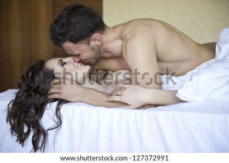 Top view of playful young couple enjoying in bed