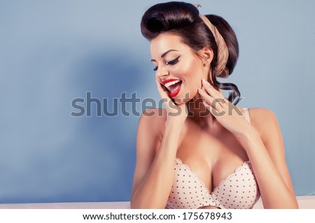 Beauty smiling pinup girl on blue wall