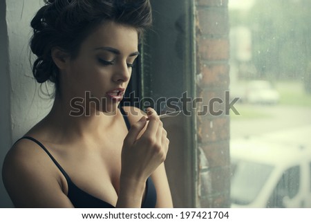 Retro style smoking fashion woman portrait in front of window