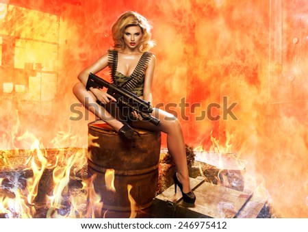 Sexy blonde woman with rifle in fire