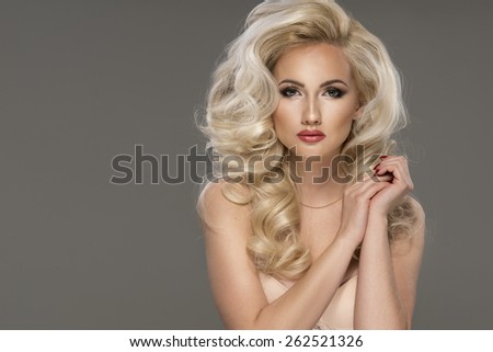 Portrait of beautiful sensual blonde woman with long curly hair. Beauty photo.