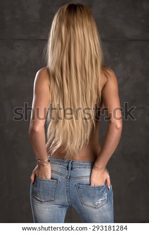 Back side of young woman with straight blonde hair only in jeans