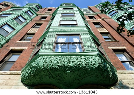 Low angle view of bay windows in a Back Bay, Boston mansion. Strong perspective and lots of carving details in verdigris copper awning.